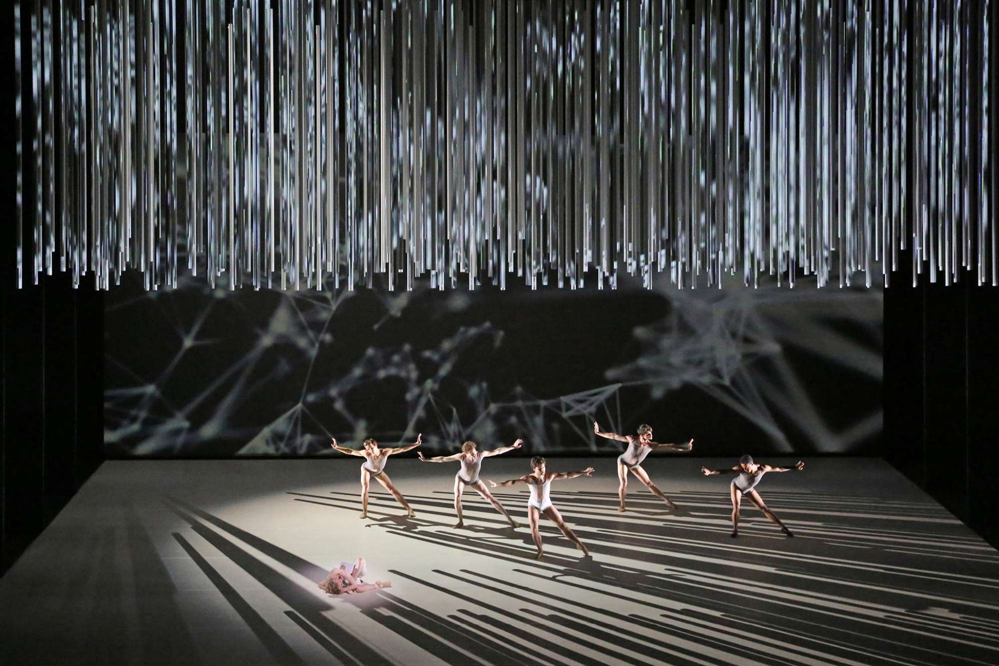Es Devlin's Connectome set for The Royal Ballet - dancers on stage in light and sharp shadows  